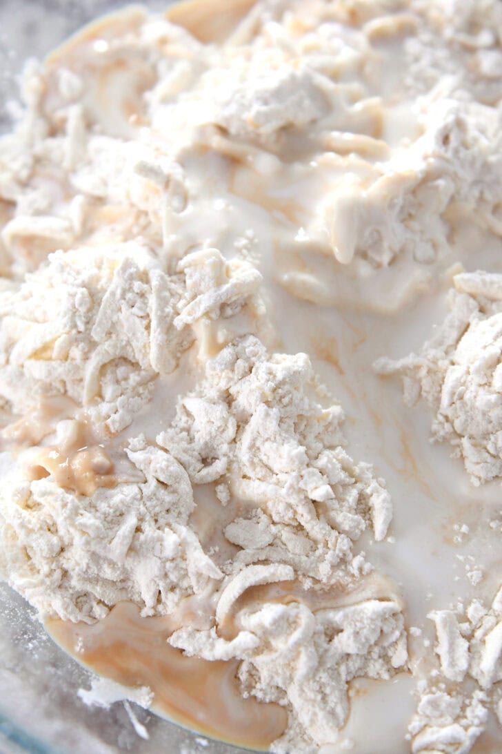 Top down view of a butter, flour, and milk mixture in a glass bowl.