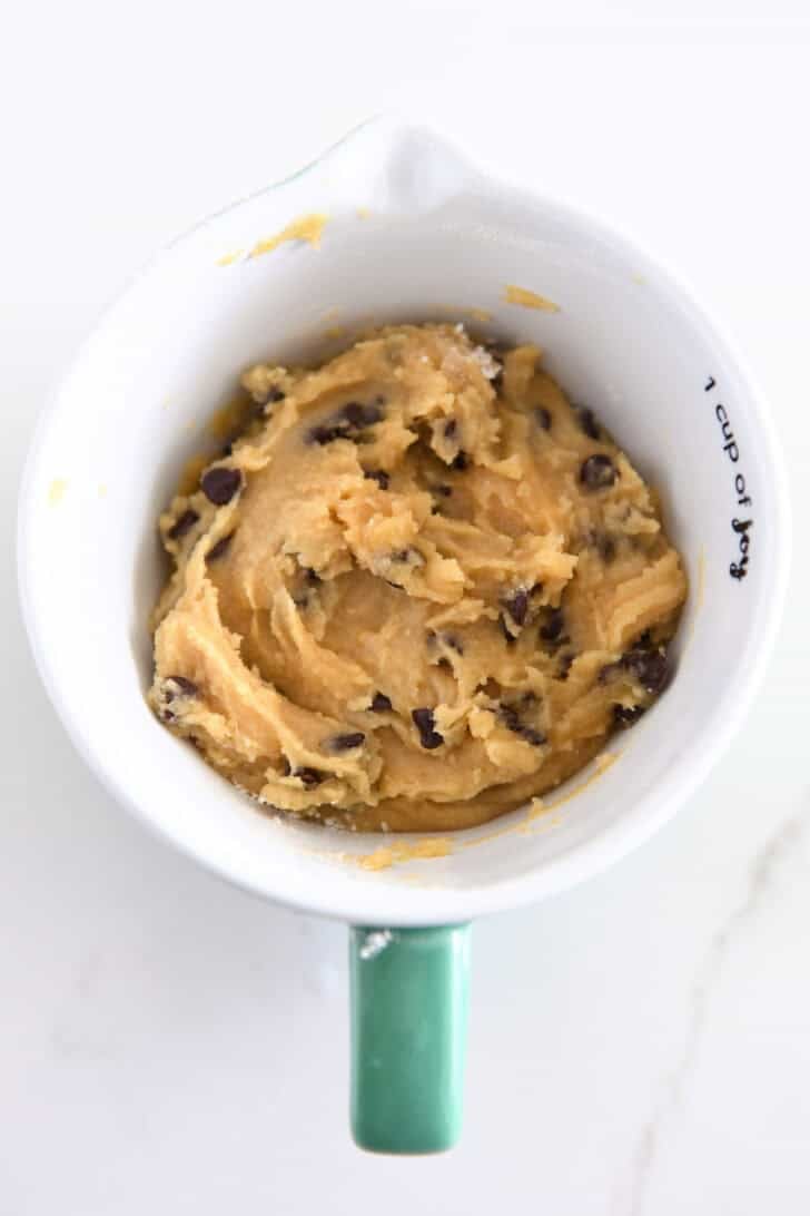 Top down view of chocolate chip cookie dough in mug.