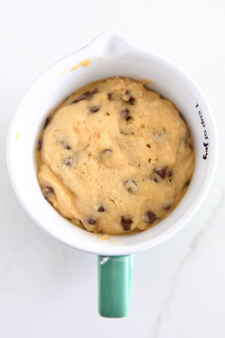 Top down view of cooked chocolate chip cookie dough in mug.