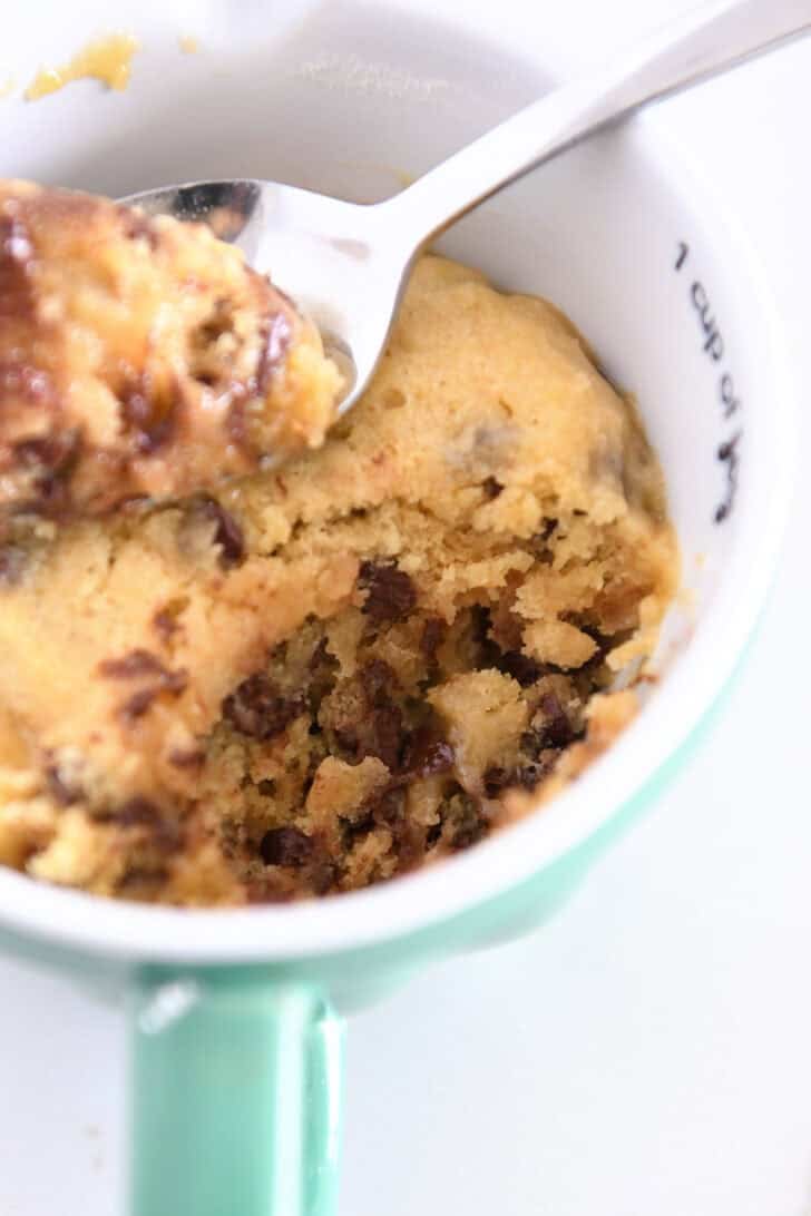 Scooped out bite of chocolate chip cookie in mug.