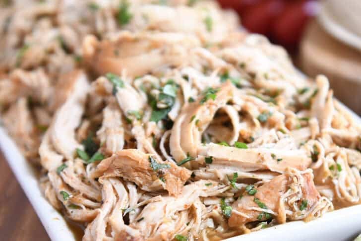 Close up view of shredded chicken topped with chopped cilantro.