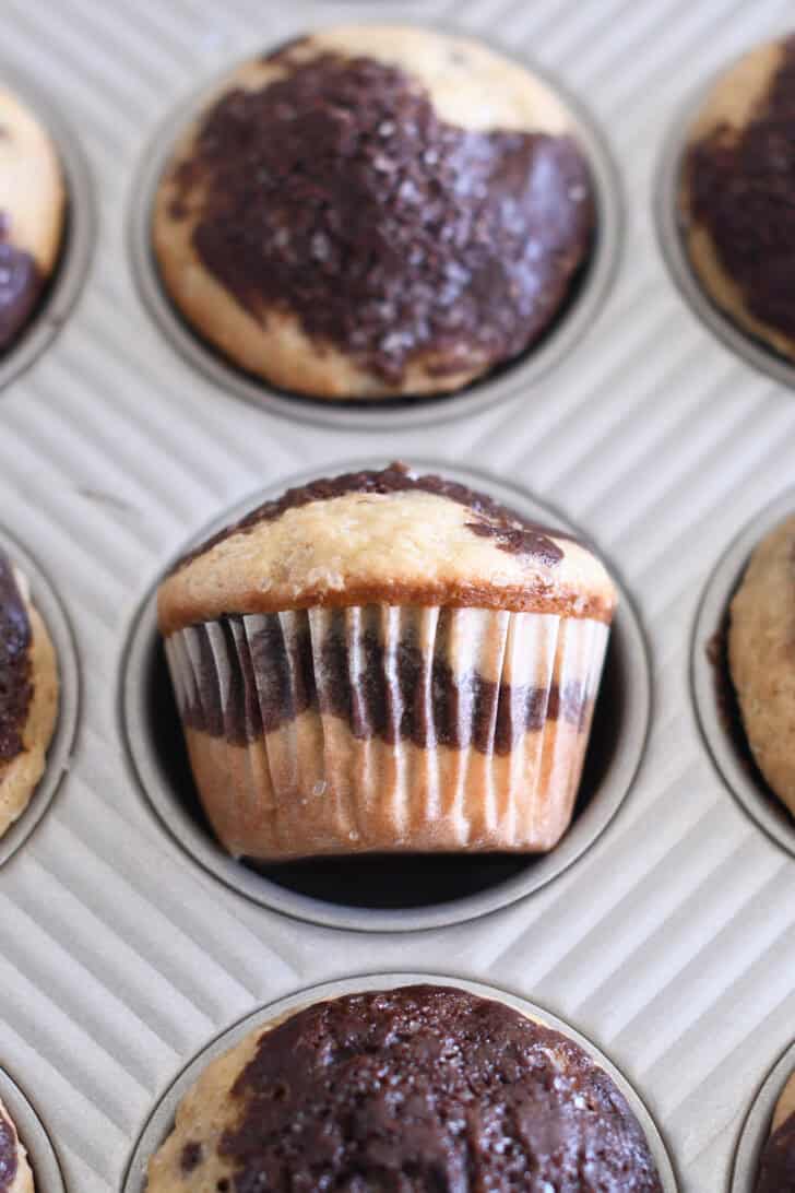 Chocolate and banana muffin turned on it's side in muffin tin.