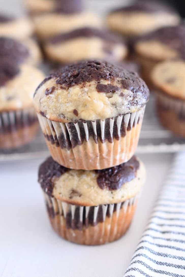 Two banana chocolate swirl muffins stacked on top of each other.