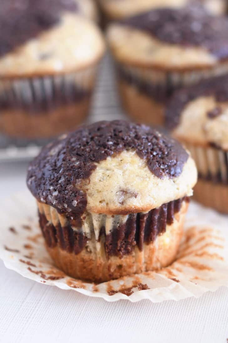 Unwrapped banana chocolate muffin on muffin liner.