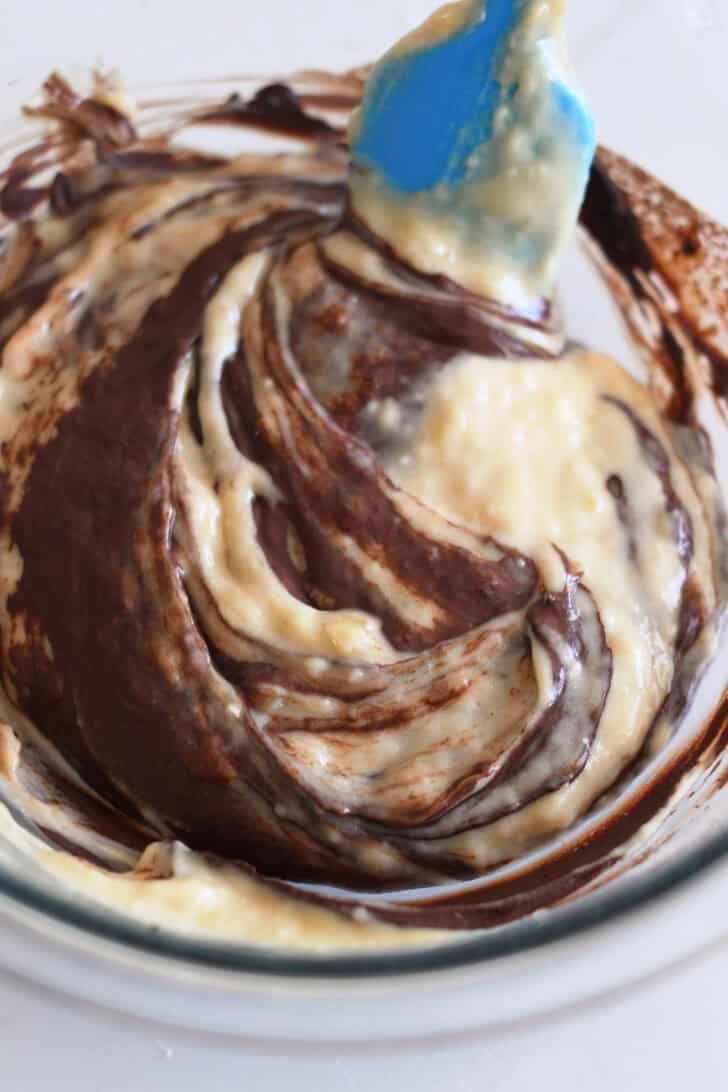 Banana muffin batter swirled with chocolate mixture.