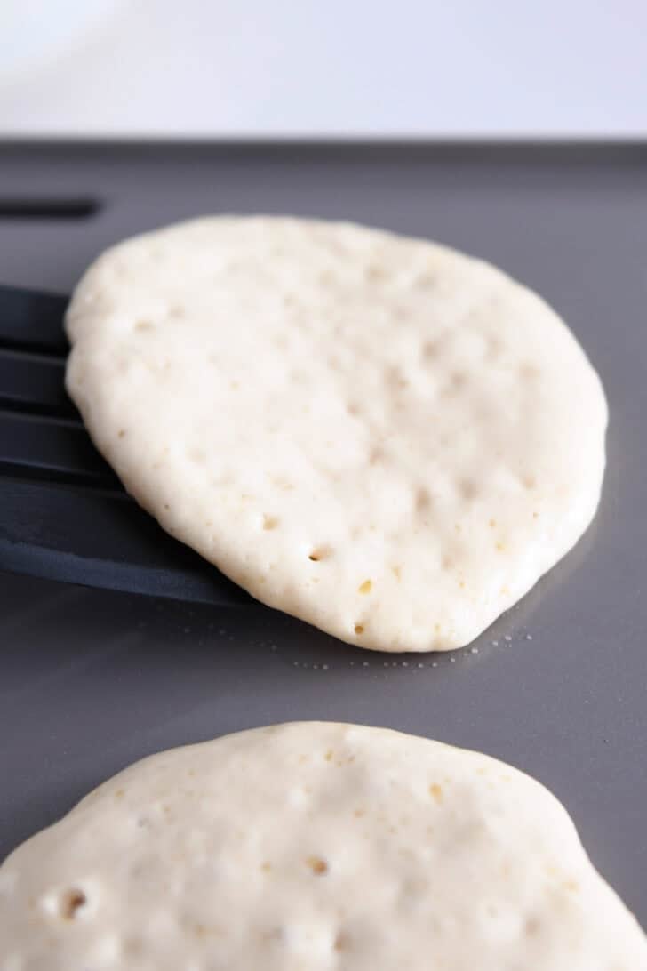Flipping pancake with black spatula.