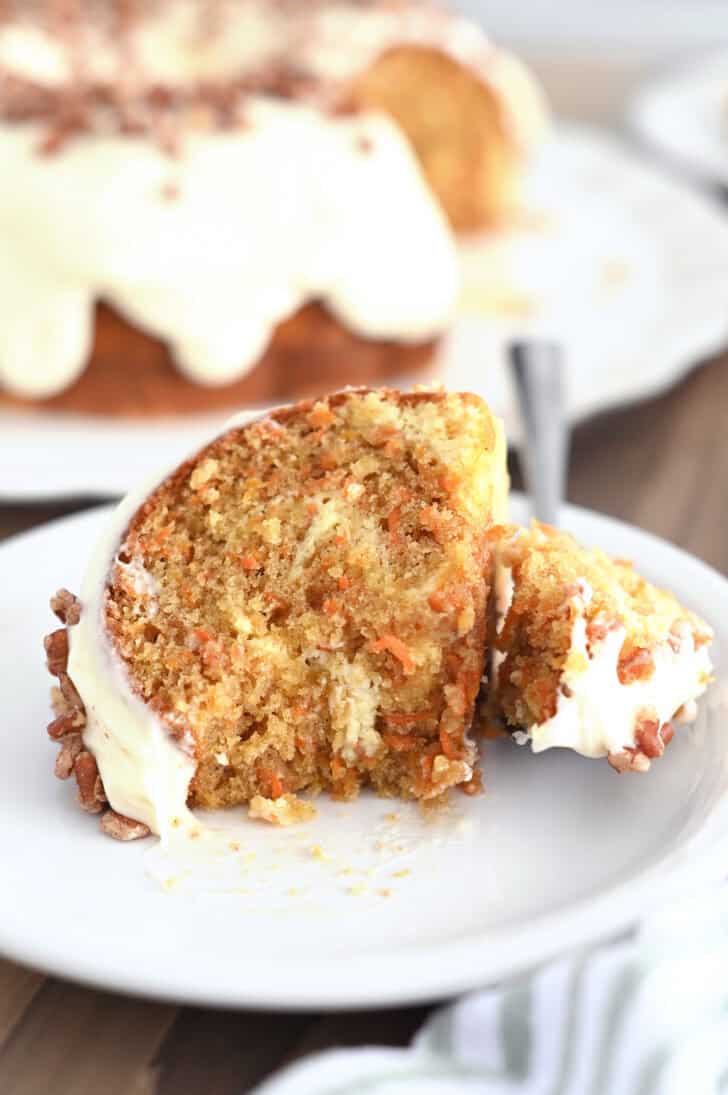 Piece of carrot cake bundt cake on white plate.