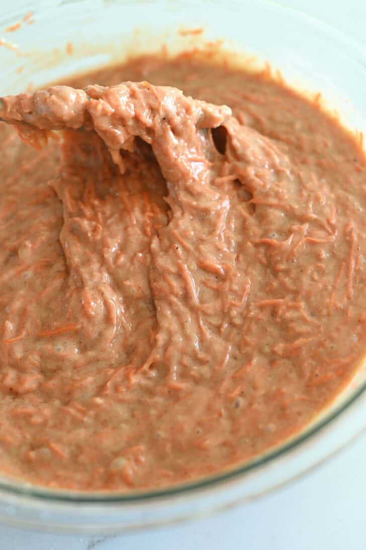 Top down view of a glass bowl with carrot cake batter.
