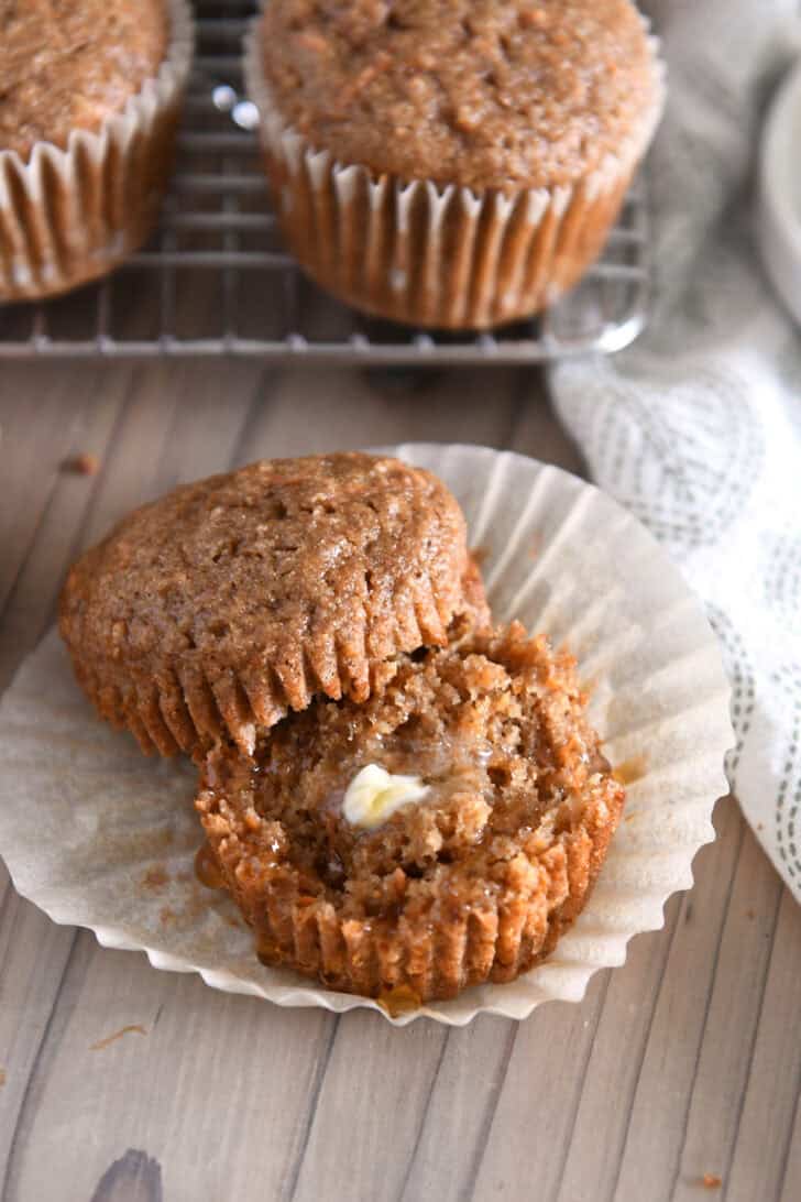 Carrot cake muffin split in half with butter and honey.