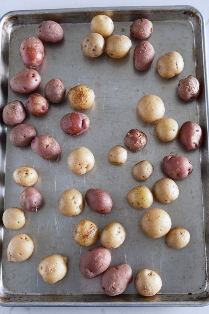 Top down view of small potatoes on half sheet pan.