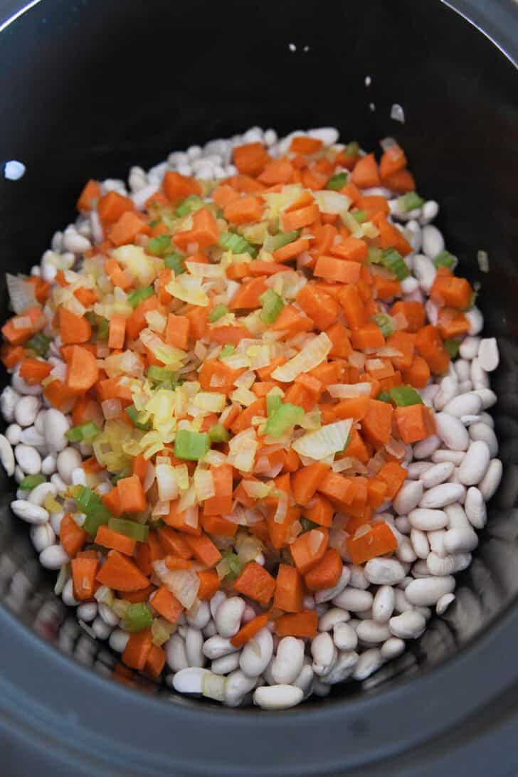 Slow cooker with dry white beans and veggies.