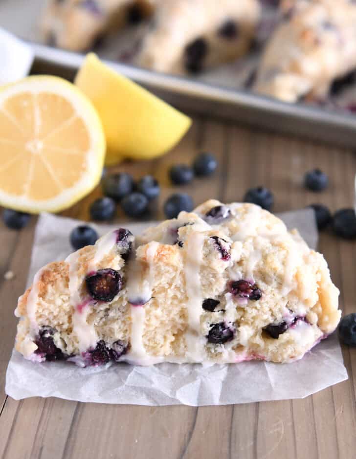 One triangle-shaped lemon blueberry scone on crumpled white parchment paper.