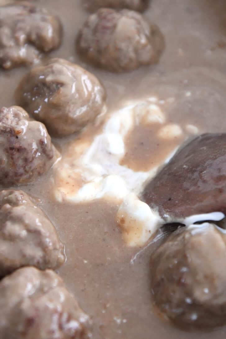 Adding sour cream to sauce for Swedish meatballs.