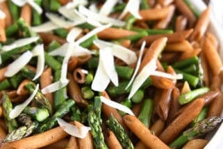 White serving dish with balsamic penne pasta, roasted asparagus and parmesan cheese.