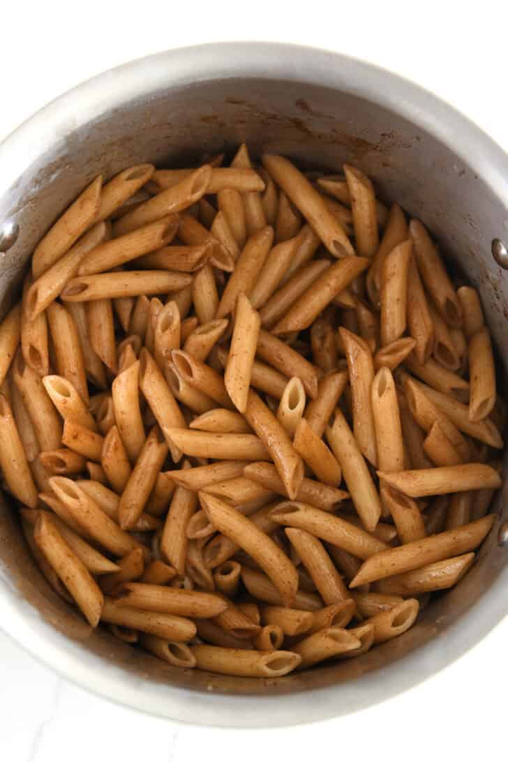 Stainless pot with penne pasta and balsamic butter.