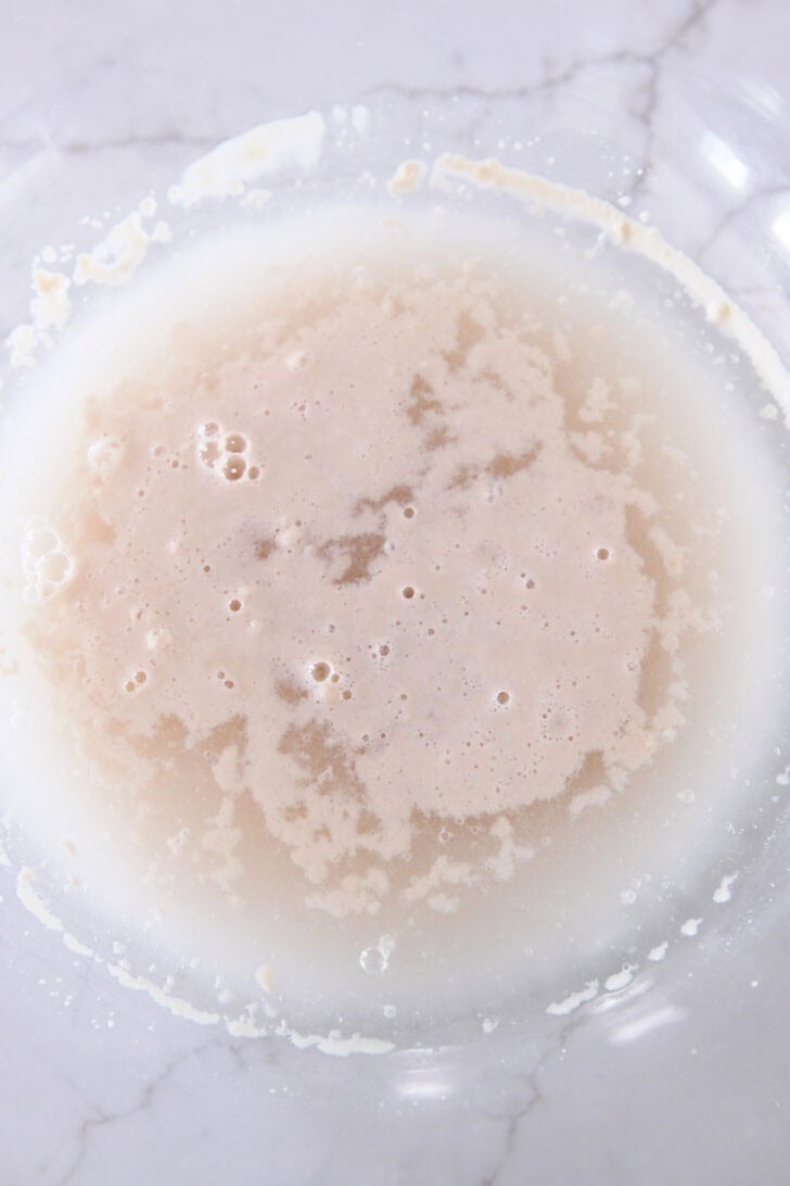 Glass bowl with warm water and yeast.