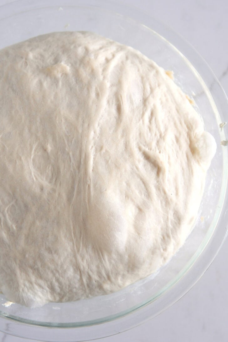 Ciabatta dough rising in glass bowl.