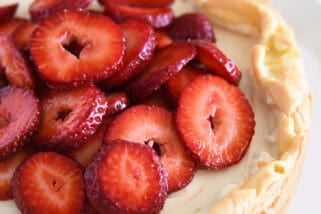 Cream puff cake topped with sliced strawberries.