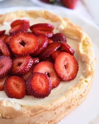 Cream puff cake topped with sliced strawberries.