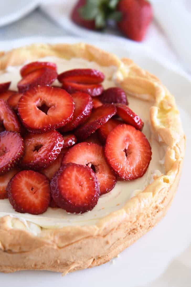 Cream puff cake topped with sliced strawberries.