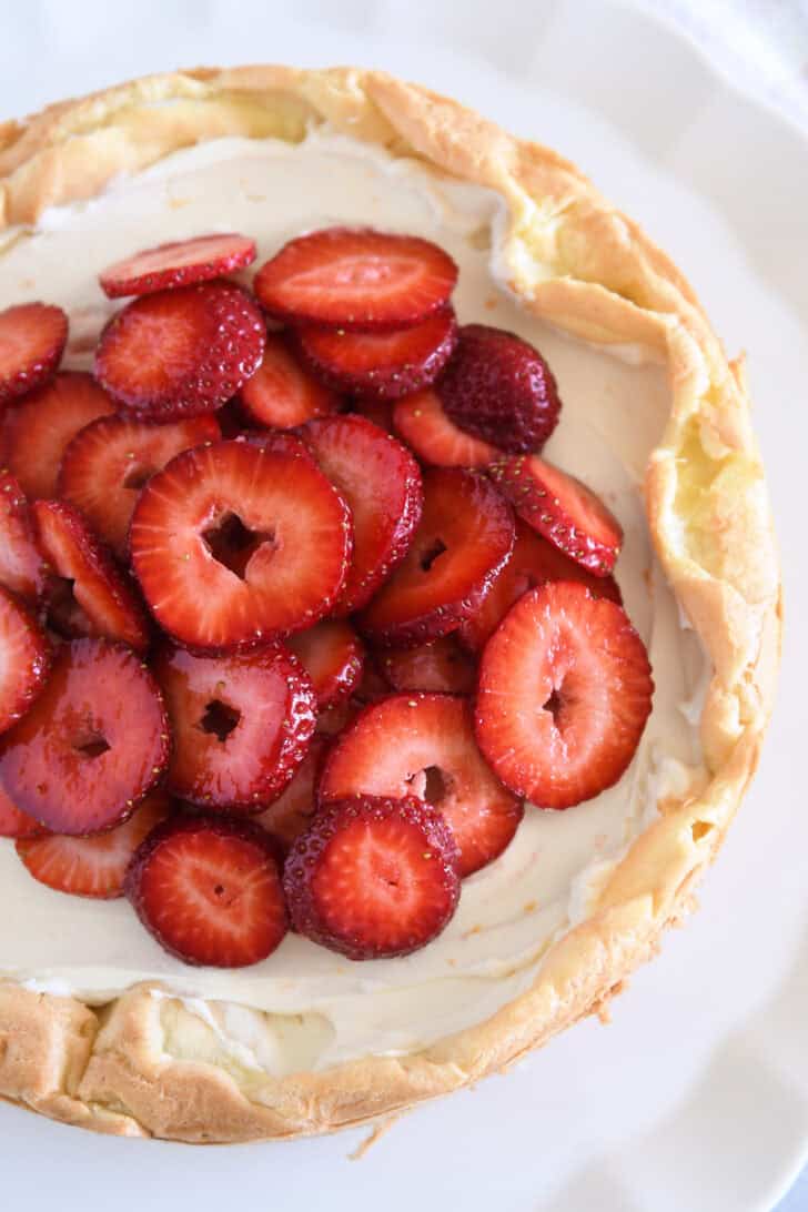 Top down view of cream puff cake topped with sliced strawberries.