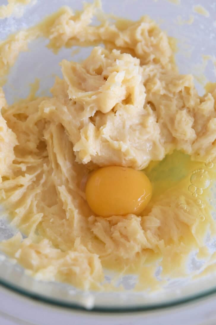 Mixed cream puff dough and egg in glass bowl.