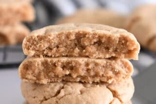 Four stacked peanut butter cookies on flat metal spatula.