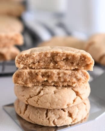 Four stacked peanut butter cookies on flat metal spatula.