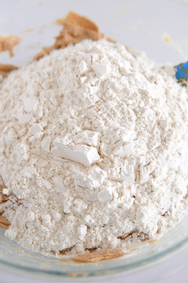Flour added to bowl with peanut butter cookie dough batter.