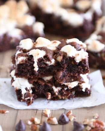 Rocky road chocolate cookie bar split in half and stacked on white parchment paper.