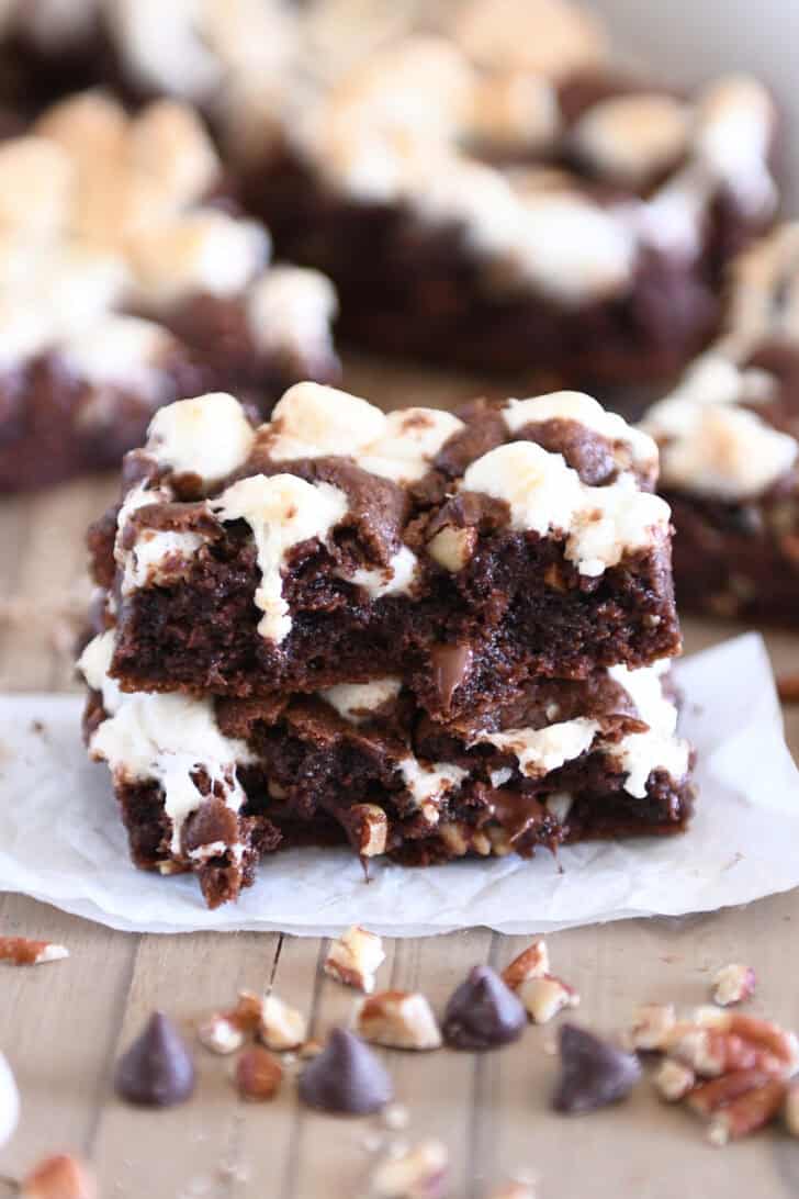Rocky road chocolate cookie bar split in half and stacked on white parchment paper.