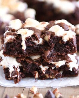 Rocky road chocolate cookie bar split in half and stacked on white parchment paper.