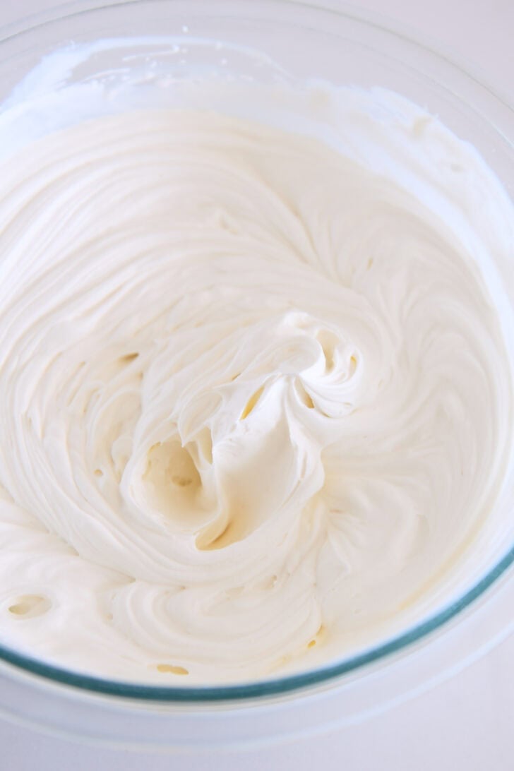 Whipped cream cheese and cream in glass bowl.