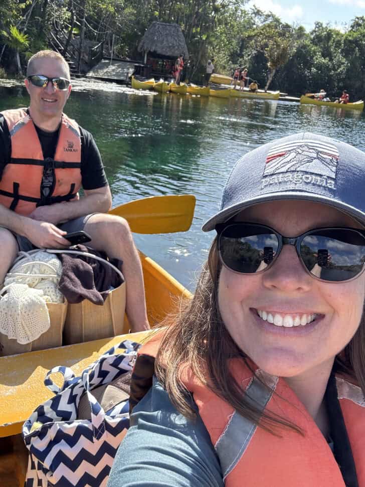 Husband and wife in yellow canoe wearing life jackets.
