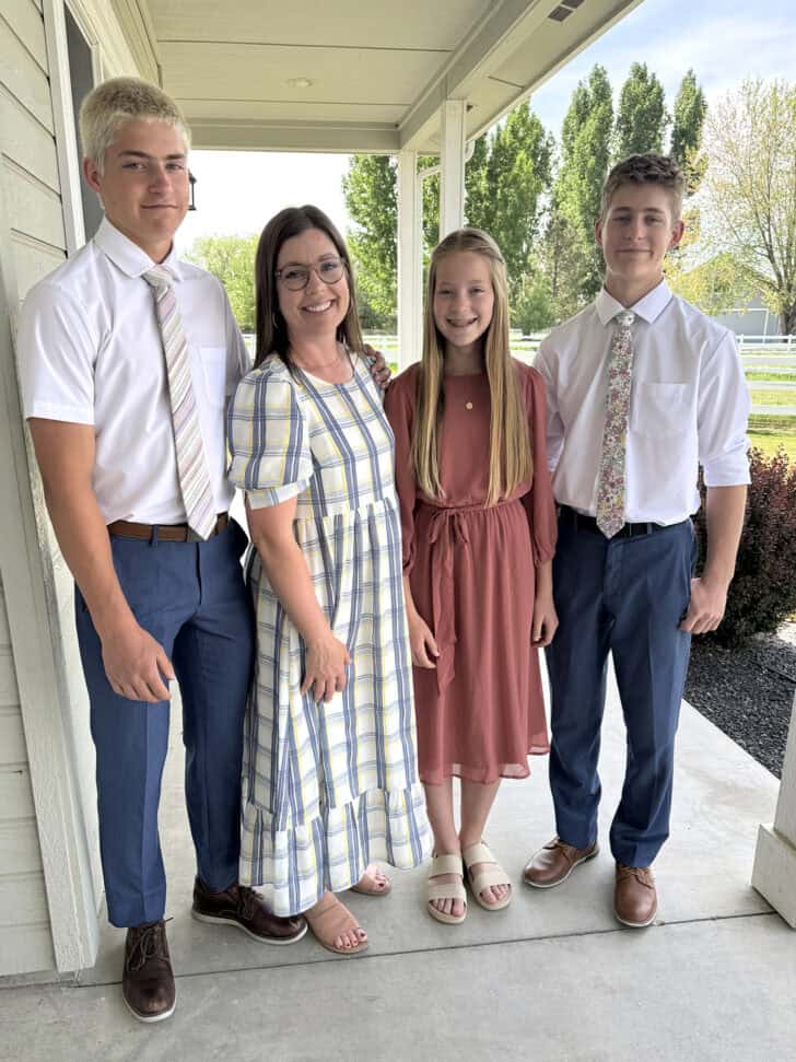 Mother and three children taking photo on front porch.