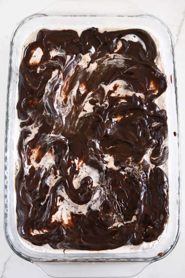 Hot fudge swirled over ice cream in glass 9X13-inch pan.