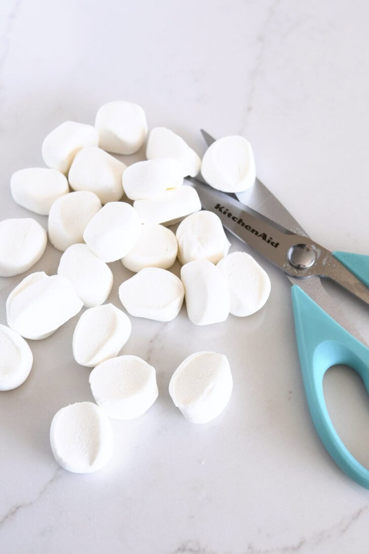 Large marshmallows cut in half with pair of kitchen scissors.
