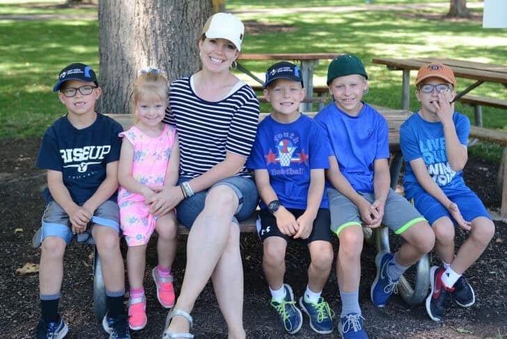 Mom with five kids sitting on bench.