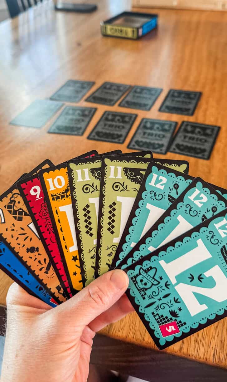 Playing Trio card game at table.