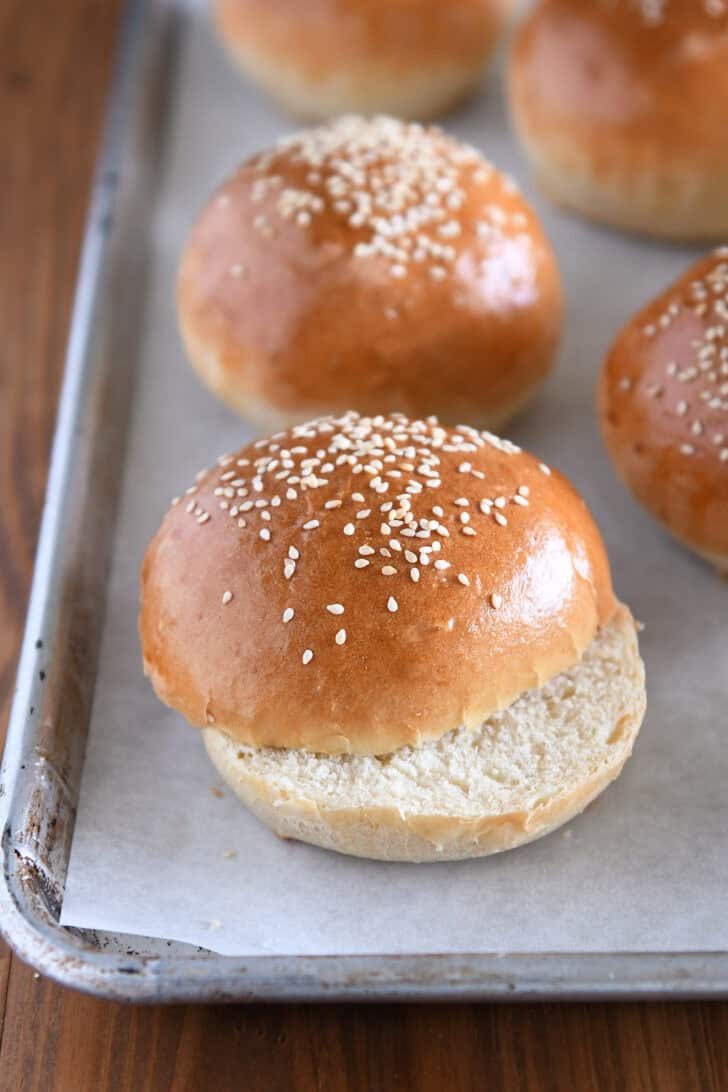 Golden baked hamburger buns with sesame seeds on top.