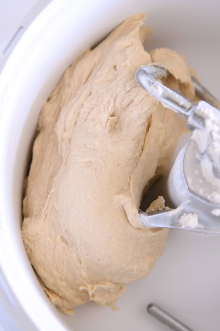 Dough pulled away from sides of bowl in mixer with dough hook.