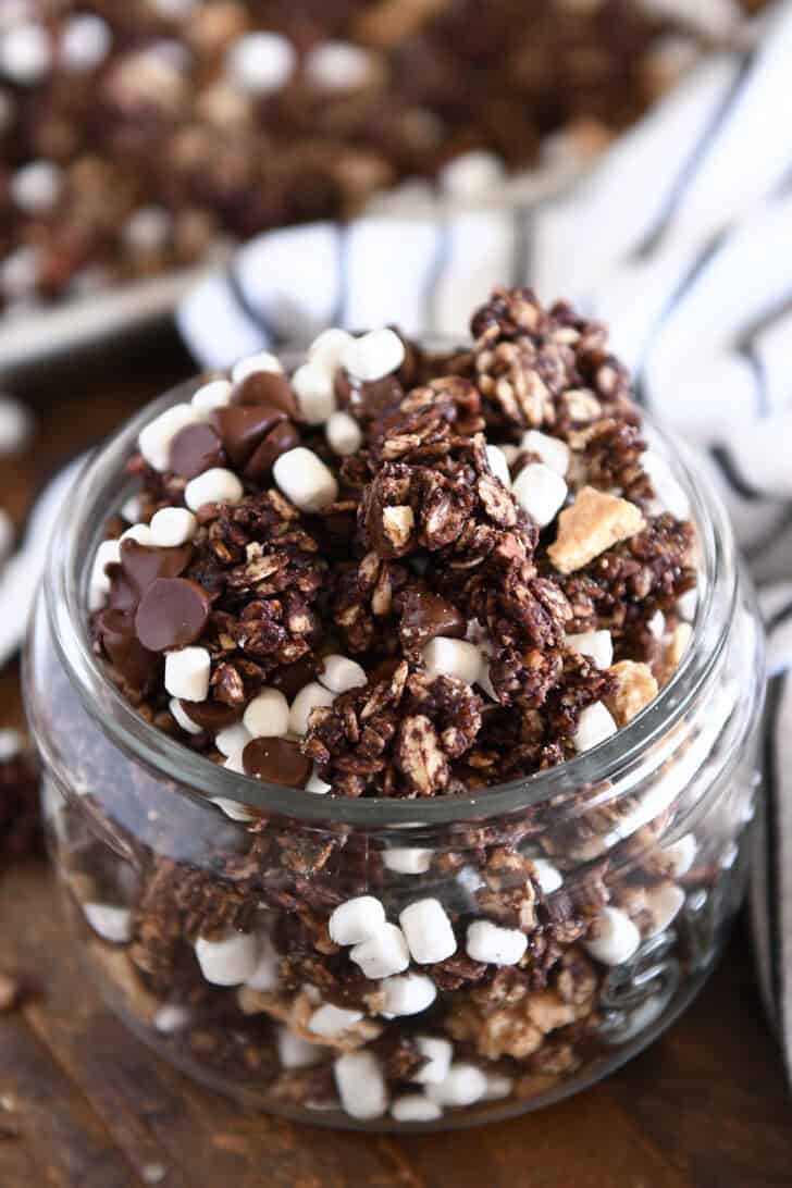 Glass jar filled with chocolate granola, graham cracker pieces and mini marshmallows.