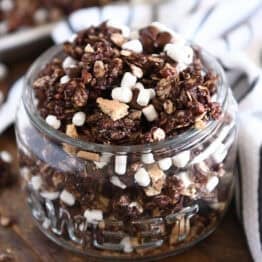 Glass jar filled with chocolate granola, graham cracker pieces and mini marshmallows.