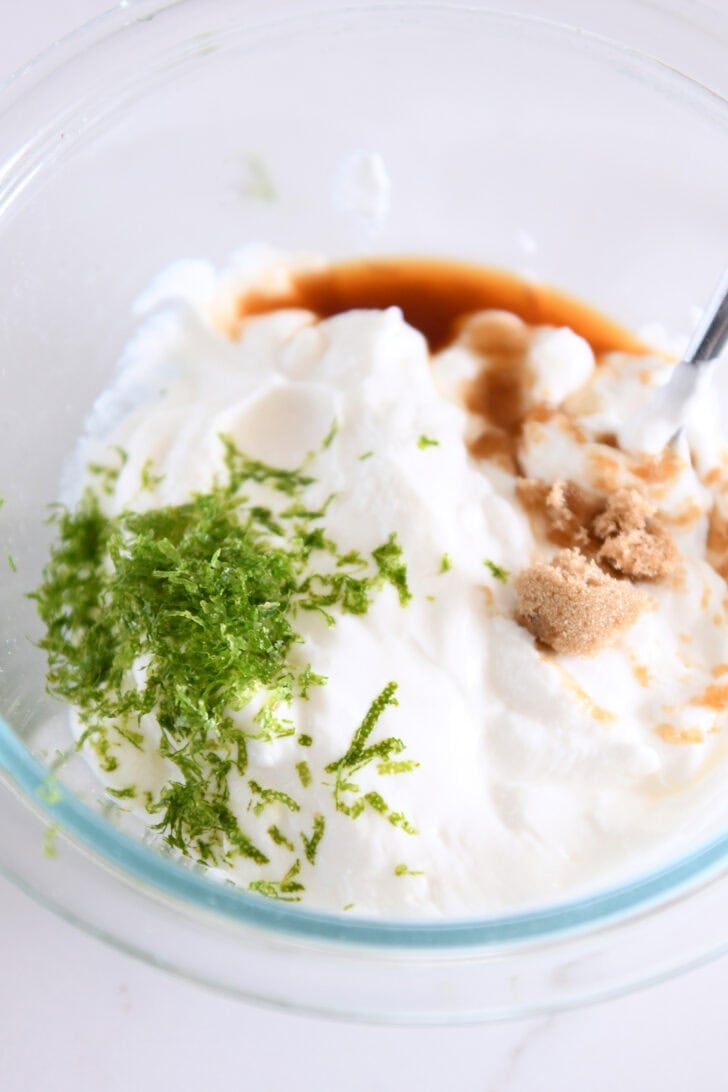 Glass bowl with lime zest, Greek yogurt, brown sugar, and vanilla.