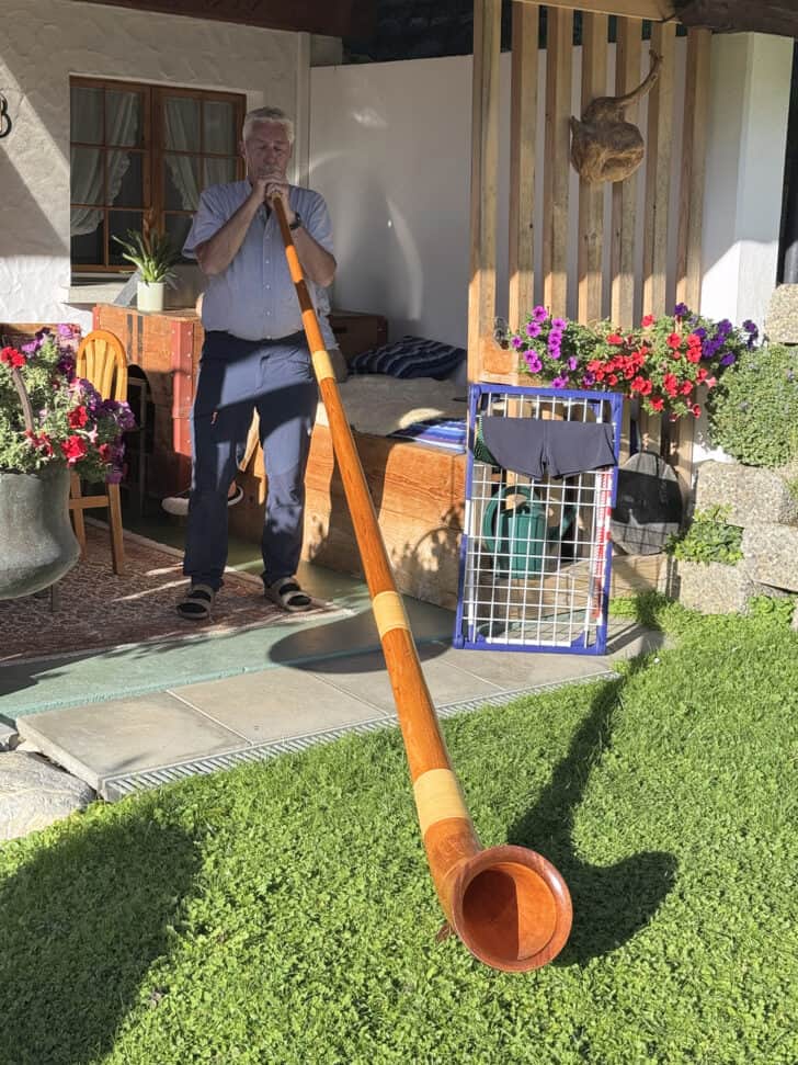 Swiss man playing alpine horn.