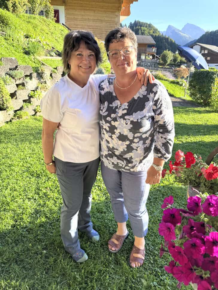 Two cousins standing together in yard of Swiss home.