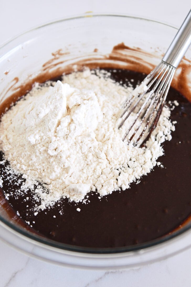Whisk in bowl with chocolate cake batter and white flour.