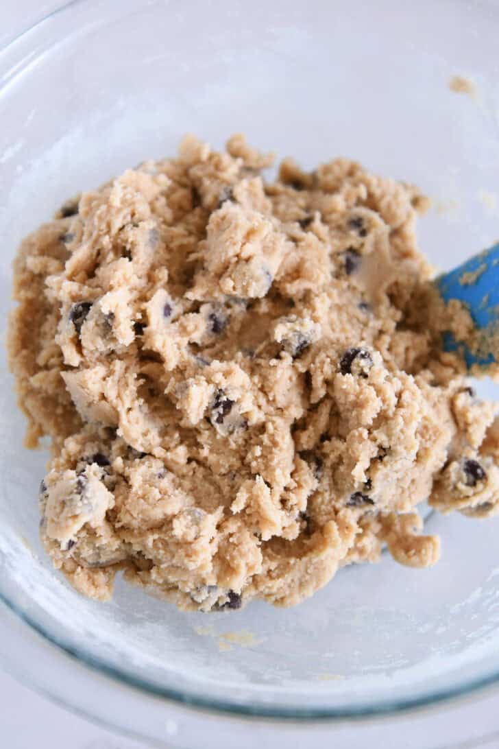 Top down view of a glass bowl with chocolate chip cookie dough.