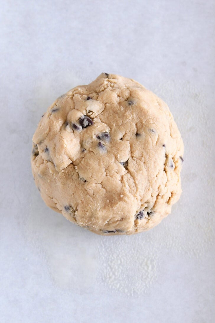 Top down view of a large ball of raw chocolate chip cookie dough.