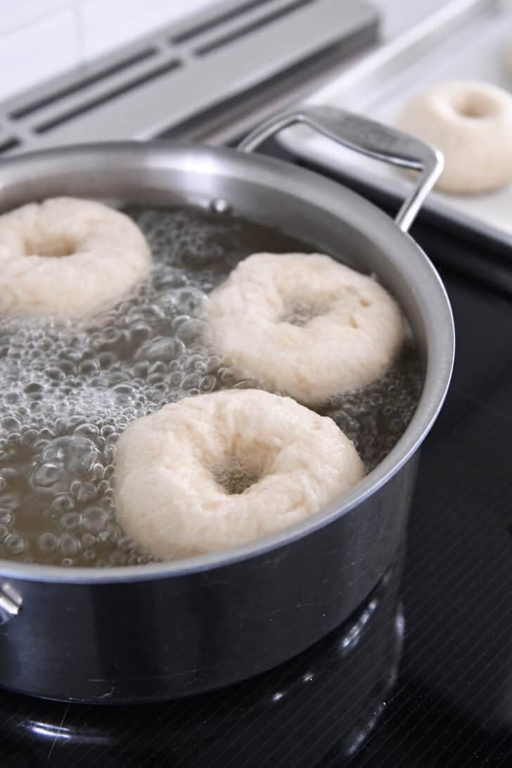 Boiling bagels in water bath with honey.
